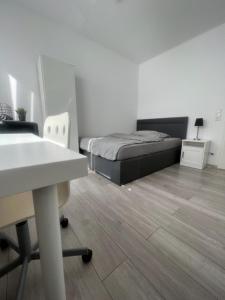 een kamer met een bed, een bureau en een tafel bij Hostel Kornwestheim in Kornwestheim