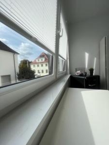 een witte vensterbank in een kamer met uitzicht op een gebouw bij Hostel Kornwestheim in Kornwestheim
