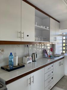 eine Küche mit weißen Schränken und einer Arbeitsplatte in der Unterkunft La Péninsule - Town Apartment No. 3 in Curepipe