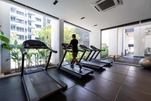 a person walking on a treadmill in a gym at Axis Residence by Caerus Management in Phnom Penh