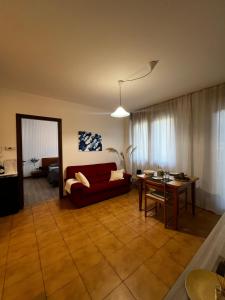sala de estar con sofá rojo y mesa en Appartamento Ai Palasi, en Vittorio Veneto