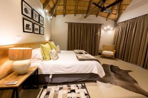 a bedroom with a bed and a table with a lamp at Elephant Rock Private Safari Lodge in Ladysmith