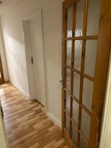 an empty room with a door and a wooden floor at Kelvin Gardens in Croydon