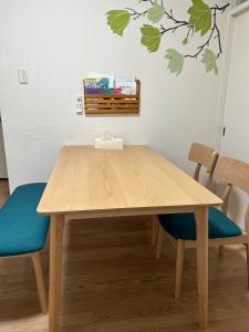 une table en bois avec deux chaises et un arbre sur le mur dans l'établissement happy house302 -駐車場無料, à Shimminatomachi