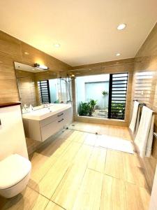 uma casa de banho com um WC, um lavatório e um espelho. em Avalon Golf Villa em Bois Chéri