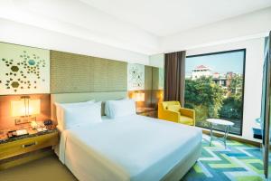 um quarto de hotel com uma cama e uma grande janela em Courtyard by Marriott Agra em Agra