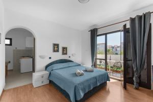ein Schlafzimmer mit einem Bett und einem großen Fenster in der Unterkunft Apartments Villa Falcon in Funtana