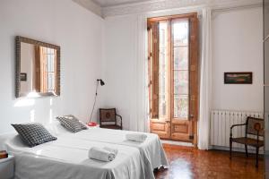 een witte slaapkamer met twee bedden en een raam bij My Address in Barcelona in Barcelona