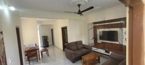 ein Wohnzimmer mit einem Sofa und einem Flachbild-TV in der Unterkunft Castle HSR Sarjapur Road in Bangalore