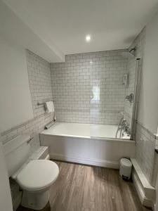 ein Badezimmer mit einer weißen Badewanne und einem WC in der Unterkunft The Bathurst Arms in Cirencester