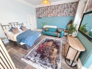 1 dormitorio con 1 cama y 1 sofá en Blue Buddha - Lemur Lodge - NEW MANAGEMENT 2024 - Bath in Bedroom with En-Suite - Short Stroll to the Beach!, en Bournemouth
