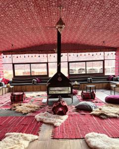 瓦迪拉姆的住宿－Bedouin Tribe Camp Wadi Rum，一间大房间,设有壁炉和大地毯