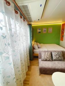 a bedroom with two beds and a couch at PTJ Style Condotel คอนโดเมืองทอง P2 in Nonthaburi