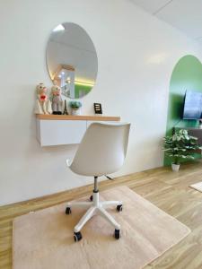 a white chair in a room with a mirror at PTJ Style Condotel คอนโดเมืองทอง P2 in Nonthaburi