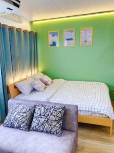 暖武里的住宿－PTJ Style Condotel คอนโดเมืองทอง P2，一间带两张床和一张沙发的卧室