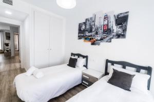 deux lits dans une chambre aux murs blancs dans l'établissement Apto. con piscinas y gym a 800 metros de playa, à El Campello 20 autres photos