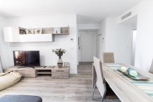 un salon avec une table et une télévision dans l'établissement Apto. con piscinas y gym a 800 metros de playa, à El Campello