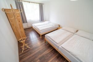 um quarto com 2 camas, um sofá e uma janela em Apartmány Olešnice em Olešnice v Orlických horách