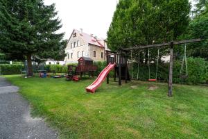 einen Spielplatz mit Rutsche im Hof in der Unterkunft Apartmány Olešnice in Olešnice v Orlických horách