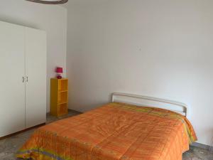 Un dormitorio con una cama con una manta naranja. en Vista Mare, en Pescara