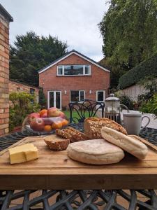uma mesa de madeira com pão e outros alimentos em BT 9 Granny Flat & walled garden em Belfast