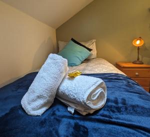 1 dormitorio con 1 cama con toallas en BT 9 Granny Flat & walled garden en Belfast