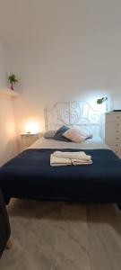 1 dormitorio con 1 cama con 2 toallas en Santos, en Málaga