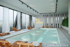 a large swimming pool in a building with chairs at H4 Hotel Wyndham Paris Pleyel Resort in Saint-Denis