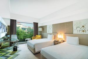 a hotel room with two beds and a window at Courtyard by Marriott Agra in Agra