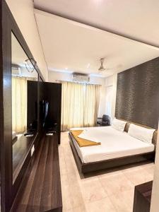 a bedroom with a bed and a television in it at Hotel Hill View Nalasopara in Sopāra