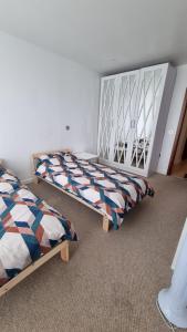 una camera con due letti e uno specchio di Luxurious 2 bedroom flat with en-suite bedroom a South Norwood