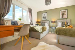a bedroom with two beds and a desk with a computer at Emerald House - Prime Location - Free Parking, Pool Table, Fast Wifi and Sky TV by Yoko Property in Milton Keynes