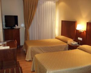 een hotelkamer met 2 bedden en een flatscreen-tv bij Casa Quiquet in Beniparrell