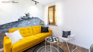 a living room with a yellow couch and a table at Wonder Home - Apartamenty w cichej okolicy, położone blisko deptaka i licznych restauracji in Karpacz