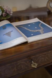 a book on a table with a necklace on it at Home The River in Rome