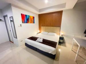 een slaapkamer met een bed en een schilderij aan de muur bij Kefir Phuket in Kamala Beach +19 foto's