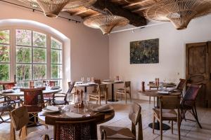 a restaurant with tables and chairs and windows at Les Petites Maisons - Hameau des Baux in Paradou