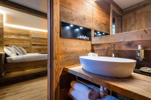 baño con lavabo blanco grande y cama en Revivre Village Adults only en Champorcher