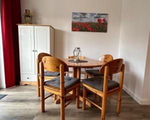 a dining room table with two chairs and a table with at Gemütliche FeWo mit Balkon nahe der Ostsee - 2 Schlafzimmer in Wischuer