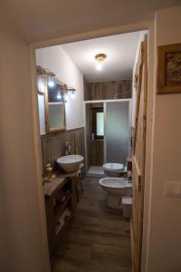 a bathroom with two sinks and two toilets at Borgo Don Camillo in Cutigliano