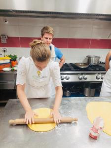 a woman in a kitchen making a dough at Il Giardino Dorato in Maiori