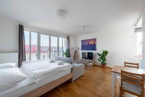 um quarto branco com uma cama grande e uma mesa em Sunny Safron apartment em Praga