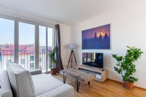 uma sala de estar com um sofá e uma televisão em Sunny Safron apartment em Praga