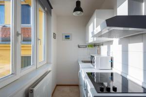 uma cozinha com um fogão e um micro-ondas em Sunny Safron apartment em Praga