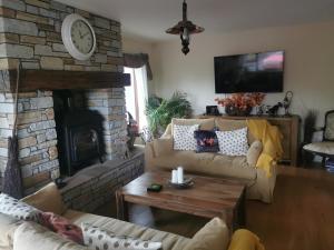 a living room with a couch and a fireplace at Cherrytree House B&B in Moville