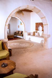 un soggiorno con arco, letto e divano di Dar Shams a Hara Srira