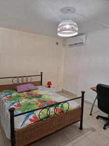 1 dormitorio con cama, silla y techo en Villannéva Calme et Spacieuse avec piscine, en Ducos