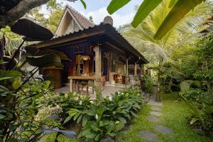 Moringa Ubud Villa في أوبود: منزل صغير وسط حديقة