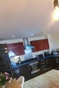 a kitchen with brown cabinets and a table in it at Luxurious and spacious 1 bd flat in Basildon
