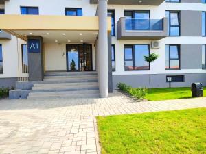 an apartment building with a staircase in front of it at Emerald Apartment On Arena Oradea in Oradea